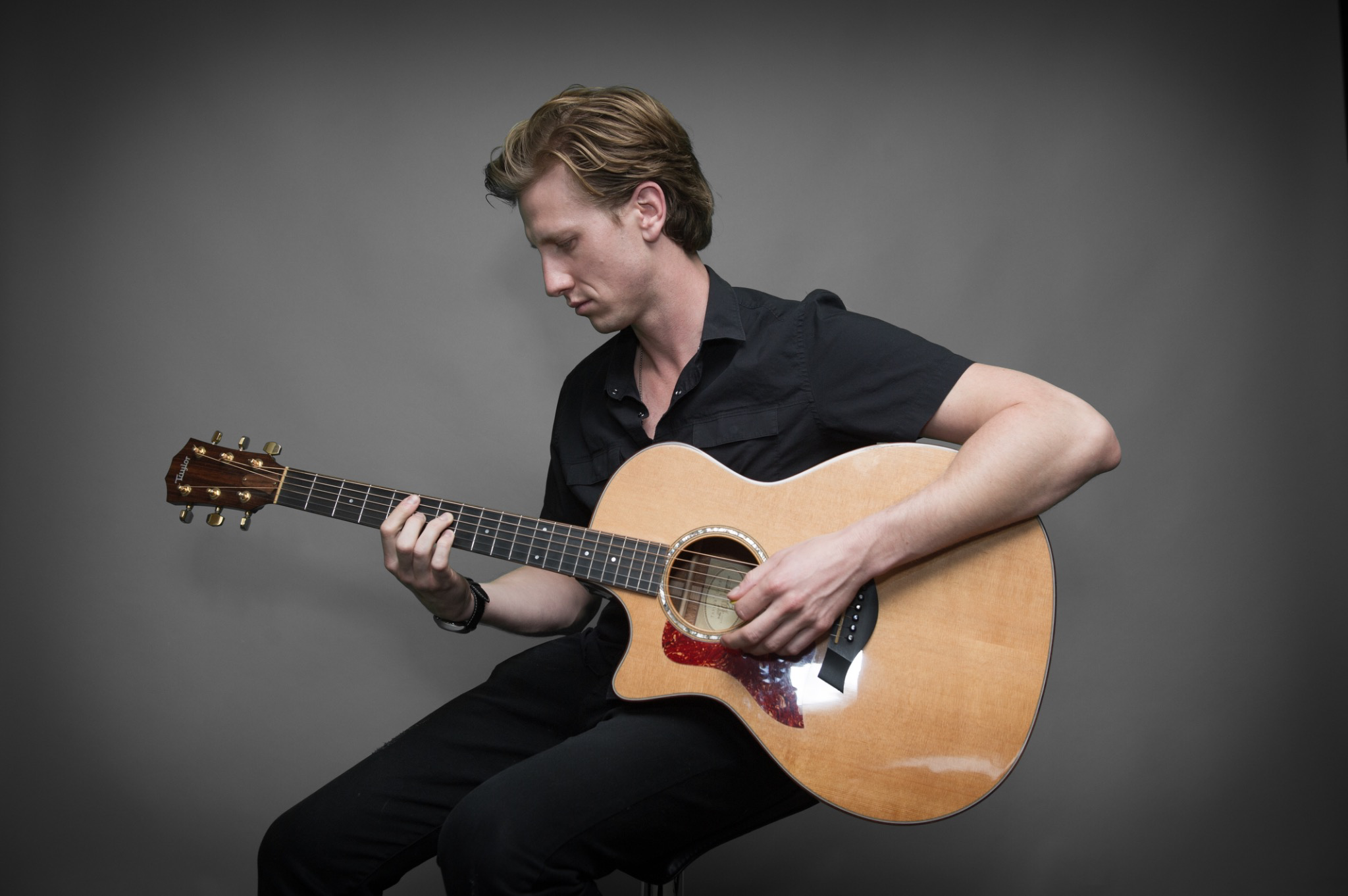 David, a San Francisco guitar teacher, seated with an acoustic guitar